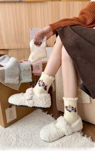Detailed texture of thick coral fleece socks with cute cartoon puppy embroidery