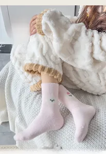 Nahaufnahme von rosa Stricksocken mit gelben Streifen und süßem Hundemuster-Detail