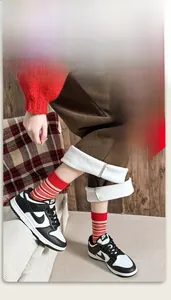 Dettagli di calzini a righe rosse abbinati a pantaloni in velluto a coste con fodera in pile