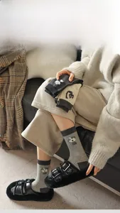 Detail of grey rib-knit crew socks with cute cartoon animal embroidery and soft texture