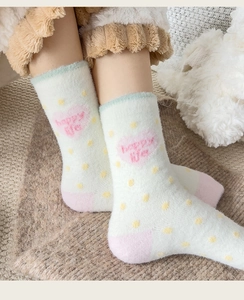 Detail von flauschigen Thermosocken mit Happy-Life-Text und rosa Herzmuster