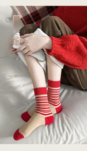 Dettaglio di calze di cotone a righe rosse e beige indossate in un ambiente caldo