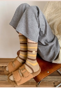 Cozy striped knit socks with bear embroidery paired with warm fleece-lined brown sandals