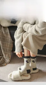 Detailed view of knitted cotton socks with cute cat pattern and grey contrast toe and heel