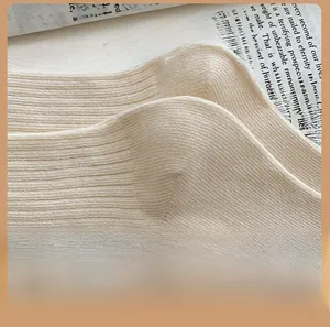 Detailed close-up of ribbed cotton knit socks with a reinforced heel on vintage book pages