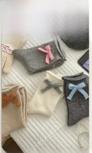 Dettaglio di calze in cotone a maglia con fiocchi e bordi arrotolati vintage