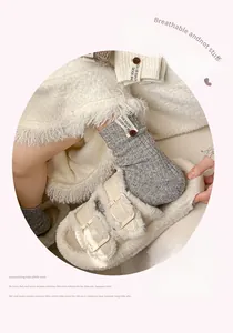 Gros plan de chaussettes en laine grise avec boutons et étiquette dans un cadre confortable