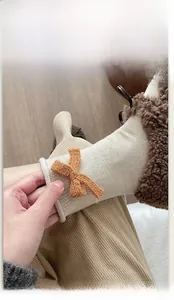 Dettaglio del polsino a coste elasticizzato e del fiocco decorativo sulle calze in maglia