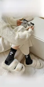 Detail of grey knitted socks featuring a cute panda pattern and vertical ribbed texture