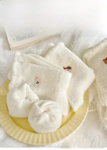 Dettaglio di calze termiche in peluche bianco con ricamo a orsetto per l'inverno