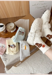 Detail of soft winter socks with cute cartoon embroidery and thick coral fleece texture