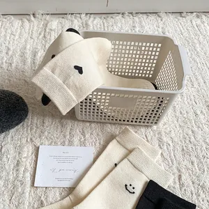 Calze spesse in cashmere beige con motivi a cuore e sorriso su tappeto di peluche morbido