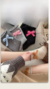 Dettaglio di calze in misto lana con fiocchi a maglia in vari colori invernali