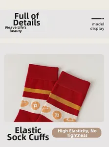 Vista macro del bordo elastico di calza rossa festiva con motivi di monete d'oro ricamate