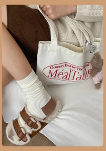 Détail du sac de courses en toile crème avec breloque ours et style automnal douillet