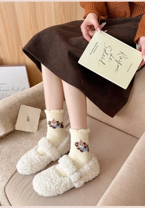 Cozy winter outfit featuring white knit socks with puppy embroidery and plush fleece slippers