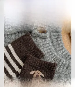Detailed view of striped wool socks with dog embroidery and elastic rib cuff finish