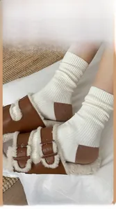 Détail de chaussettes en laine tricotées et de pantoufles en cuir à peau d'agneau