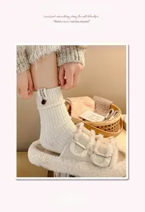 Détail de chaussettes en laine mélangée avec étiquette boutonnée en décor intérieur