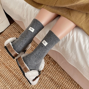 Gray knit mid-calf socks with egg label and plush cork slippers for cozy winter home style