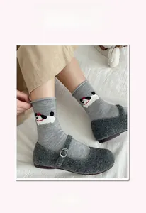 Close-up of gray wool socks featuring a cute cartoon dog embroidery and ribbed cuffs