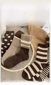 Detail of assorted vintage brown wool socks featuring polka dots and stripes in a basket