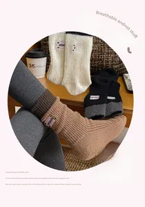 Close-up of knit crew socks with embroidered letters and ribbed texture details