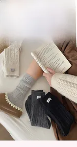 Detail of wool socks with egg label paired with cozy slippers in a warm home setting