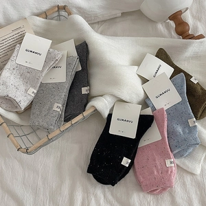 Confetti knit mid-calf socks in various colors displayed in a decorative metal basket