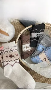 Close-up of five pairs of warm Fair Isle wool socks with vintage dog patterns in a basket
