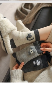 Detailed view of three pairs of mid-calf cotton socks with cute 3D cat and panda embroidery