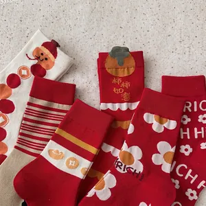 Calze festive in cotone rosso e beige con motivi di cachi e simboli portafortuna