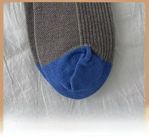 Détail macro de la pointe bleue renforcée sur des chaussettes d'hiver épaisses marron