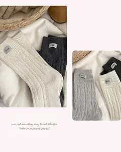 Detail of wool knit socks with cable pattern and egg label in multiple warm colors