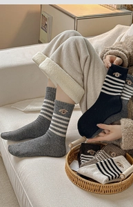 Detailed view of winter wool socks featuring striped patterns and dog embroidery detail