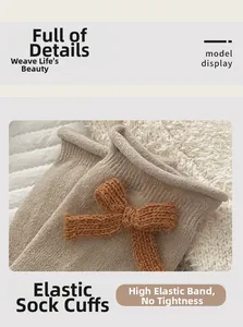 Dettaglio di calzini in maglia beige chiaro con fiocco arancione e polsini elastici a coste