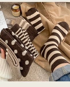 Flat lay of warm wool crew socks in brown tones with stripe and polka dot patterns