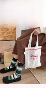 Detail of Fair Isle knit socks with vintage patterns and a minimalist tote bag display