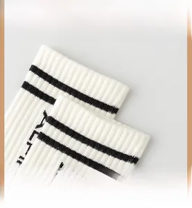 Detail of white knit sports socks showing black stripes and high-elastic ribbed texture