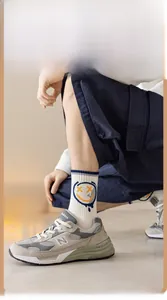Détail de chaussettes en coton blanc avec rayures bleues et motif sourire graffiti