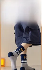 Détail de chaussettes en coton bleu marine avec smiley jaune et texte Peaceful