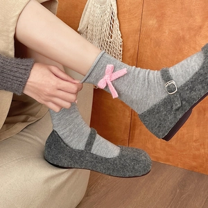 Scarpe Mary Jane in lana grigio scuro con calze grigie e fiocco rosa decorativo