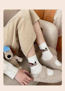 Detail view of cute cartoon puppy embroidery on white mid-calf cotton socks for women