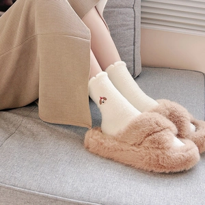 Set invernale con calzini bianchi ricamati e pantofole di peluche marroni morbide
