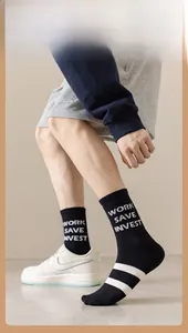 Detail of men's black mid-calf socks with 'WORK SAVE INVEST' text and white stripes