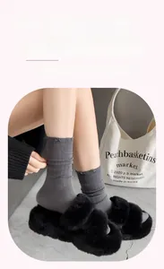 Detailed view of dark grey ribbed socks with pink bow embroidery on the cotton fabric