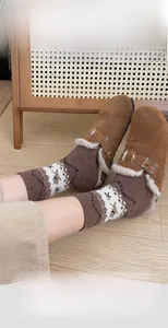 Fair Isle pattern wool socks styled with brown suede mules on a cozy wooden floor