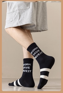 Close-up of black cotton crew socks featuring white WORK SAVE INVEST text and stripes