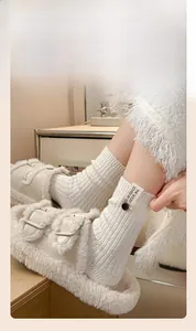 Détail de chaussettes en laine avec étiquette et bouton, portées avec des pantoufles