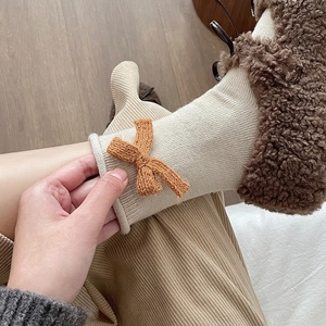 Calze da donna in maglia color avena con fiocco marrone e trama a costine